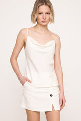 A model wearing The Grace Cami in a clean, minimalist white silhouette paired with a matching skirt, embodying timeless elegance and versatile capsule wardrobe style.