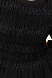Close-up of The Vivienne Peplum Blouse showcasing its textured, ruched black fabric with delicate lace detailing, reflecting timeless minimalist design for a refined capsule wardrobe.