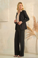 Woman wearing The Worth Avenue Trousers in black, styled with a beige blouse and black blazer, showcasing a timeless and versatile capsule wardrobe look.