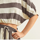 Close-up of a cropped top and matching bottoms in wide neutral stripes featuring The Miou Muse Boat Neck Stripe Top with a boat neckline, designed for a timeless capsule wardrobe.