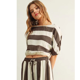 A model wearing The Miou Muse Boat Neck Stripe Top featuring wide horizontal stripes in neutral tones, showcasing a clean, timeless design perfect for a curated capsule wardrobe.