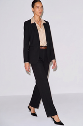 Model wearing The Worth Avenue Trousers styled with a black blazer, beige satin blouse, brown belt, and black pointed-toe heels, showcasing a timeless minimalist workwear look.