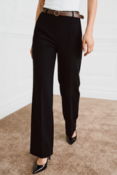 The Worth Avenue Trousers in black feature a clean, tailored silhouette with a high waist, paired with a brown belt and glossy black pointed-toe heels for a refined, minimalist look.