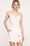 A model wearing The Grace Cami in a clean, minimalist white silhouette paired with a matching skirt, embodying timeless elegance and versatile capsule wardrobe style.