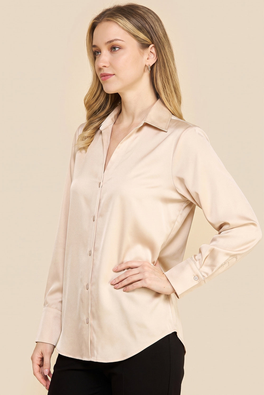 Woman wearing an Oyster Satin Blouse with long sleeves and a soft sheen, styled in a minimalist and timeless design ideal for a refined capsule wardrobe.
