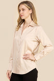 Woman wearing an Oyster Satin Blouse with long sleeves and a soft sheen, styled in a minimalist and timeless design ideal for a refined capsule wardrobe.