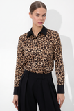 Woman wearing a Leopard Print Satin Blouse with black collar and cuffs, paired with high-waisted black trousers, showcasing a timeless minimal and refined capsule wardrobe piece.