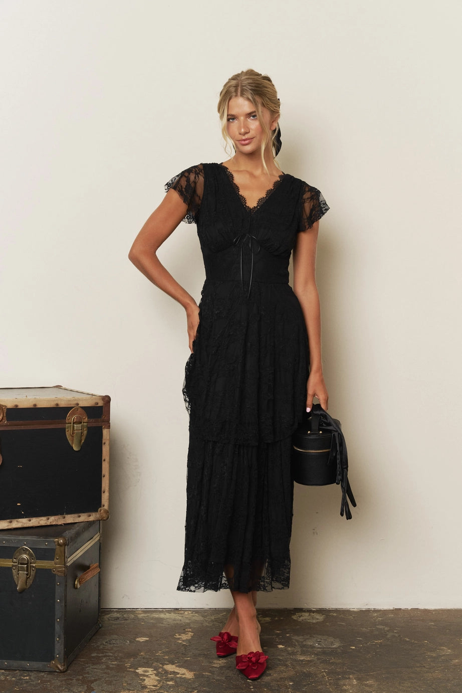 Orient Express Black Lace Maxi Dress – Whimsigoth Holiday & NYE Gown, woman wearing a tiered black lace maxi dress with red shoes and a black handbag
