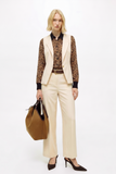 Model wearing Oyster Belted Wide Leg Trousers paired with a leopard satin blouse and cream vest, accessorized with a brown leather belt, large tan handbag, and pointed heels, showcasing a modern minimalist capsule wardrobe look.