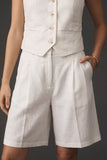A close-up of a model wearing The Palma Linen Set in a neutral, breathable fabric featuring tailored high-waisted shorts with a clean, minimal design and a matching buttoned vest.