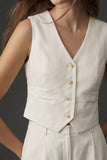 Close-up of a woman wearing The Palma Linen Set featuring a sleeveless, button-front linen vest in a soft ivory tone, showcasing clean lines and minimalist design.